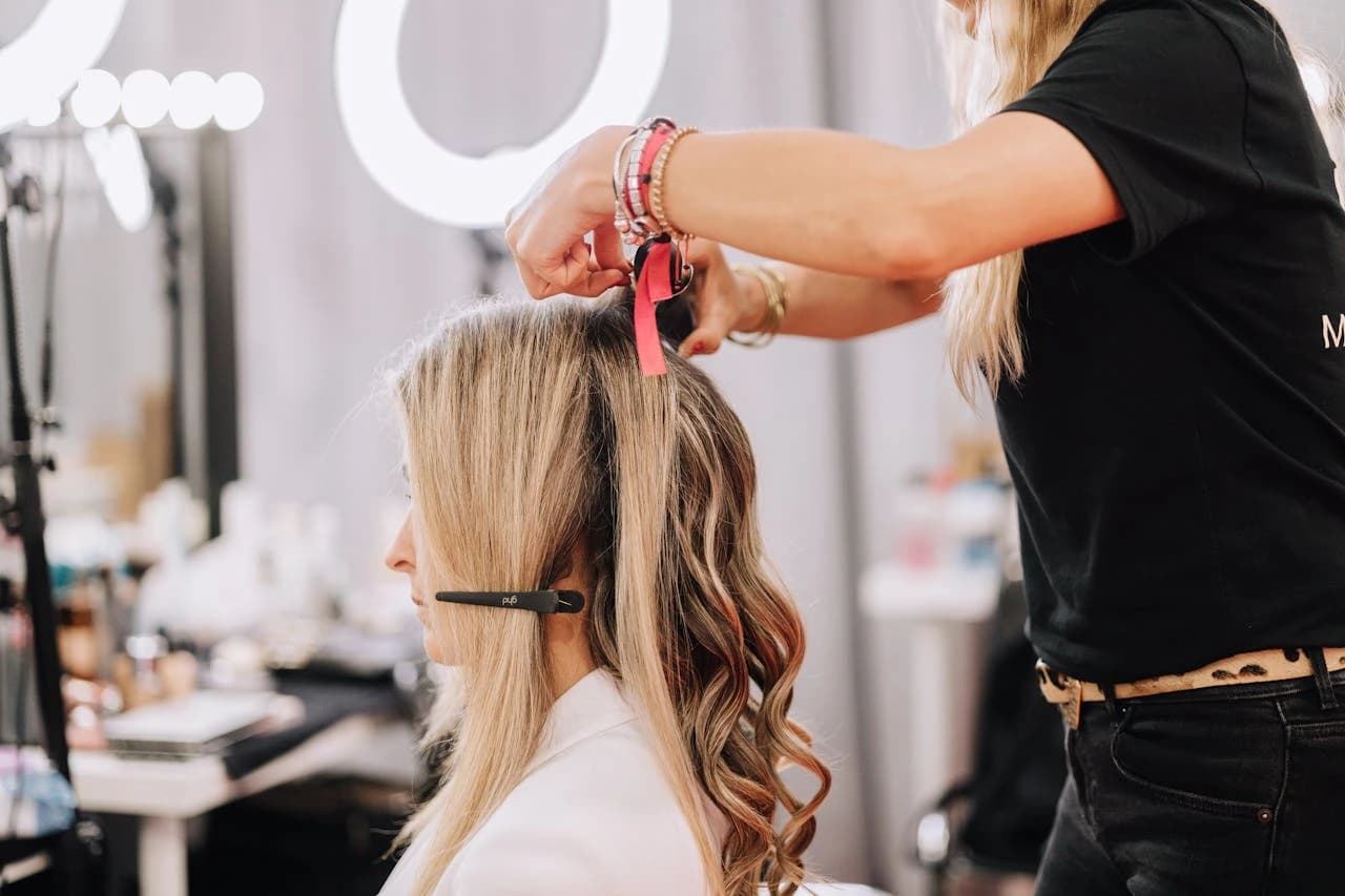 Stylistin formt Wellen im blonden Haar